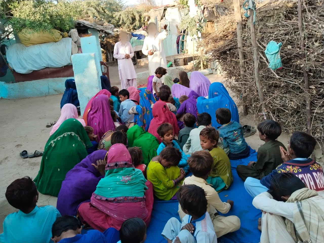 Leaders of an underground church speaking to families gathered in a courtyard